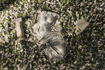 Ancient female torso next to columns covered by travertine stones. 3D Rendering