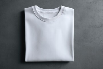 Folded white t-shirt on a gray surface
