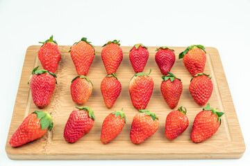 Fresh strawberries neatly arranged on the cutting board