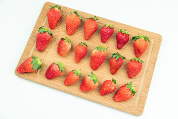Fresh strawberries neatly arranged on the cutting board