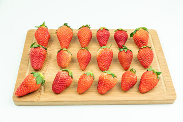 Fresh strawberries neatly arranged on the cutting board