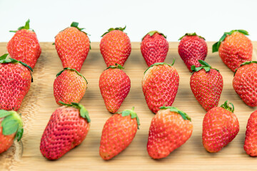 Fresh strawberries neatly arranged on the cutting board