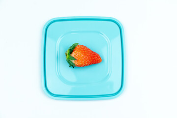 A fresh strawberry on the lid of the lunch box