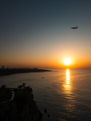 Aerial view of the sun rising over the ocean, light glimmering across the surface as waves move slowly. Perfect for cinematic openings, travel reels, or nature documentaries.