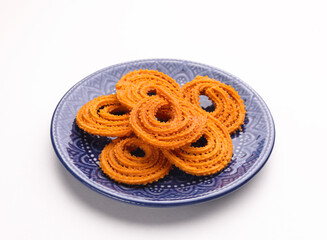 Indian Snacks popular in Diwali Festival Called Chakali serve in plate isolated on white background 