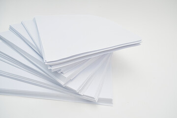 A stack of white paper sheets arranged in a fan shape.
