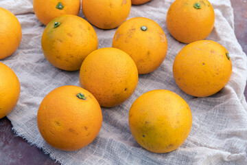 Fresh fruit, candied oranges, are neatly placed on the fabric