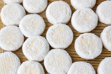 Small heads of crottin goat cheese  on a bamboo sticks.