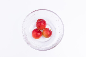 The fresh red plums in the glass bowl