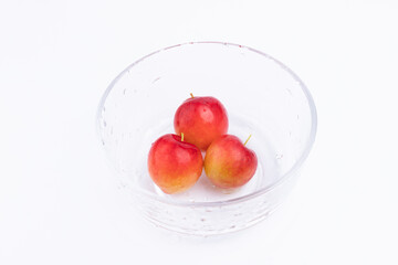 The fresh red plums in the glass bowl