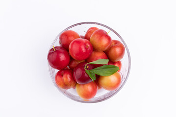 The fresh red plums in the glass bowl