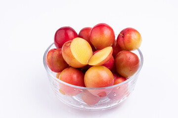 The fresh red plums in the glass bowl