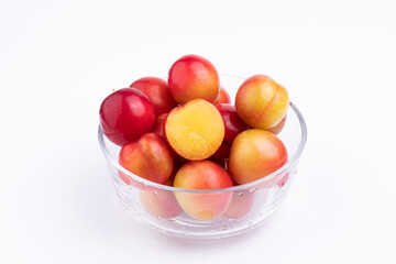The fresh red plums in the glass bowl