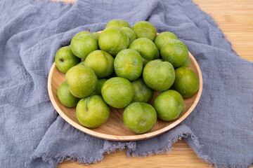 Fresh plums in the wooden plate