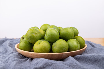 Fresh plums in the wooden plate