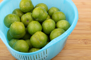 Drain the fresh plums in the basket