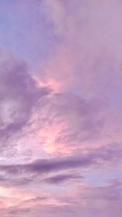 Vertical shot of pastel sky with purple and pink clouds during sunset, soft and dreamy atmosphere perfect for backgrounds, mood boards, or aesthetic visuals.