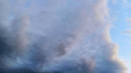 Overcast sky with thick gray clouds and soft blue tones, atmospheric and moody backdrop suitable for weather, nature, or cinematic backgrounds.