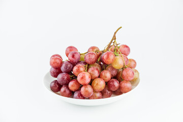 A bunch of fresh grapes and fruits on a white plate