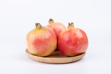 Fresh pomegranates in the wooden plate