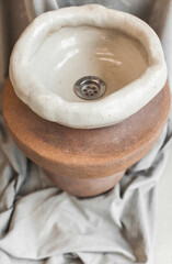 Minimalist still life of handmade ceramic decor in earthy tones. Unique pottery pieces for interior styling: vases, lamps, mirror frames, and home accessories with natural textures