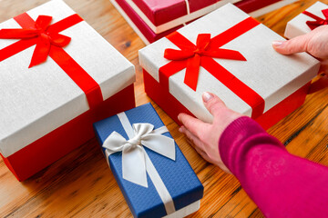 Wrapping Gifts with Decorative Ribbons. Festively Wrapped Gift Boxes on Wooden Surface.Gift Box...