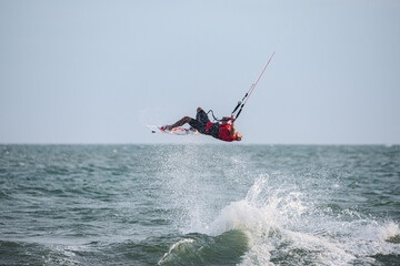 extreme kitesurfer riding a kite on the waves in the sea