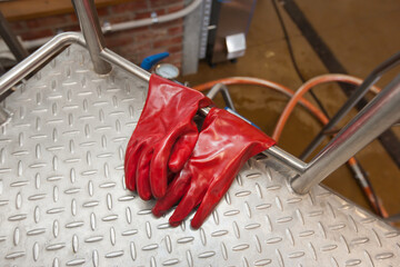 Heavy duty gloves hanging from a platform at a microbrewery