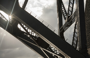 Sunburst through partial structure of Sydney Harbour Bridge against the sky