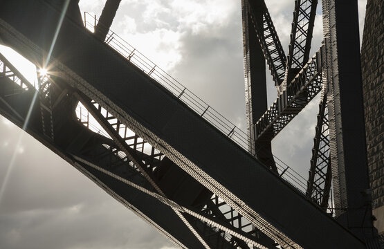Sunburst through partial structure of Sydney Harbour Bridge against the sky