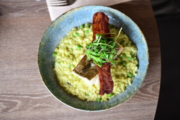 Top View of Pea Risotto with Cod and Crispy Bacon – Spring-Inspired Restaurant Dish