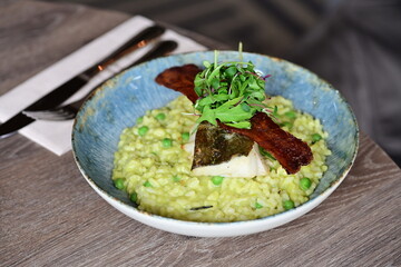 Top View of Pea Risotto with Cod and Crispy Bacon – Spring-Inspired Restaurant Dish