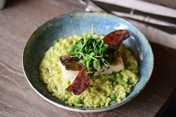 Top View of Pea Risotto with Cod and Crispy Bacon – Spring-Inspired Restaurant Dish