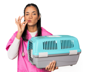 Young Filipina vet holding pet carrier with fingers on lips keeping a secret.