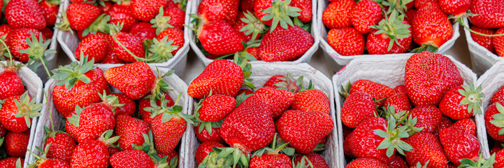 Fresh strawberries arranged in baskets at a market during summer harvest season