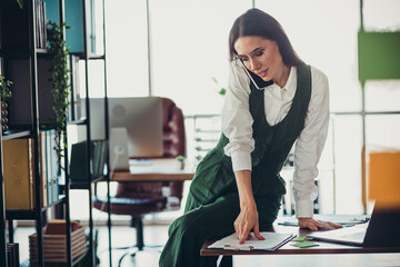 Confident businesswoman conducting work in a professional modern office environment with focus and...