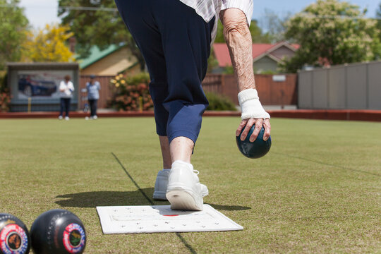 Older woman delivering a lawn bowl