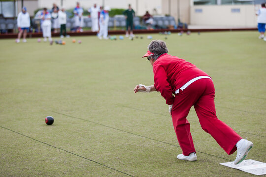 Older woman delivering a lawn bowl