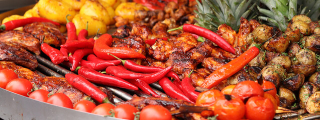 Food fair, food court. Potatoes with parsley, grilled vegetables, pineapples, fish and peppers. Selling different products at the fair. Street food to take away, festival. Delicious food