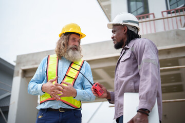 Construction workers discussing in Architecture housing project at a construction site, showcasing teamwork and project coordination.
