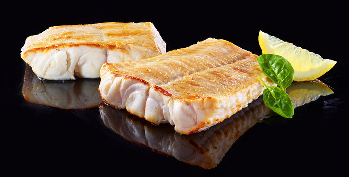 Steinbeisser Filet auf schwarzem Spiegelfond, Fisch, gebraten, isoliert, 