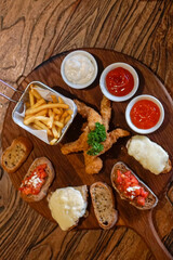 A wooden serving board displays an assortment of appetizers