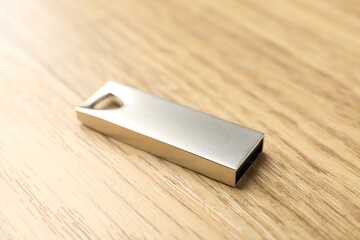 One flash drive on wooden background, closeup