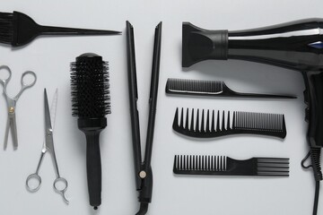 Different hairstyling tools on white background, flat lay
