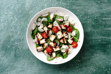 Healthy Spinach and Chicken Breast Salad with Radish, Cherry Tomatoes, Sesame Seeds, Olive Oil, and Balsamic Vinegar