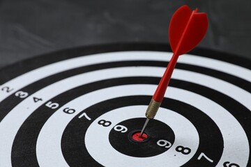 Targeting. Dart board with arrow on gray background, closeup