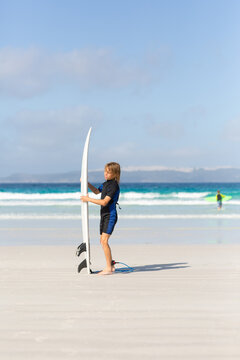Young boy with surfboard on the beach