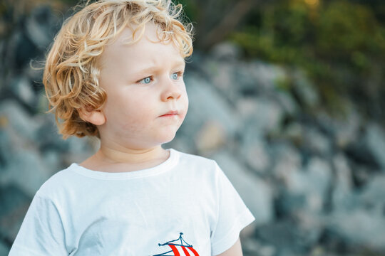 Close up portrait of little boy thoughtfully gazing into the distance