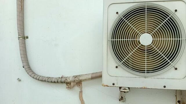 The AC unit is running with the pipe slightly peeled off.