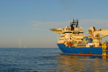 Offshore DP3 Cable Laying Vessel Deploying Subsea Cable Next To Substation Installation During Wind...